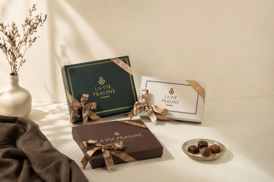 La Vie Praliné hediye kutuları; yeşil, krem ve kahverengi kutular altın kurdeleyle bağlanmış