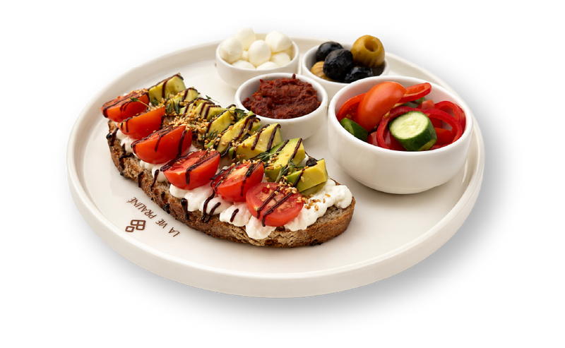 Sur Du Pain — ekşi mayalı ekmek üzerinde avokado, çeri domates ve kahvaltı eşlikçileri